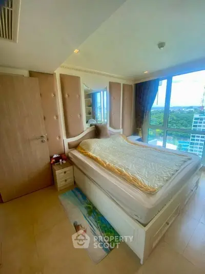 Bright bedroom with large windows offering stunning city views and elegant decor.