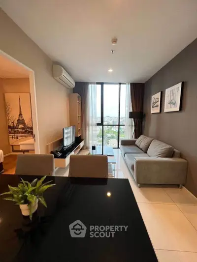 Modern living room with sleek furniture and large window offering city view