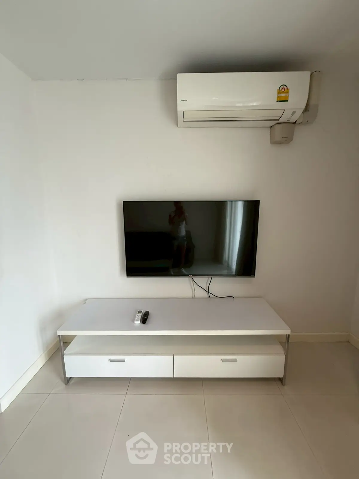 Modern minimalist living room with wall-mounted TV and air conditioning