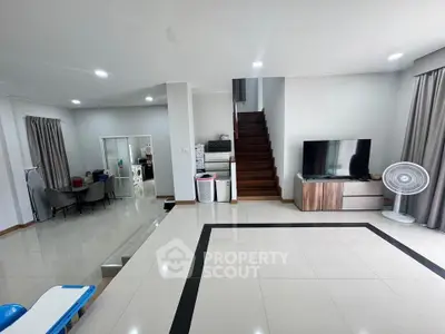 Spacious modern living room with sleek design and staircase leading to upper floor