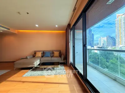 Spacious living room with modern decor and stunning city view from balcony.