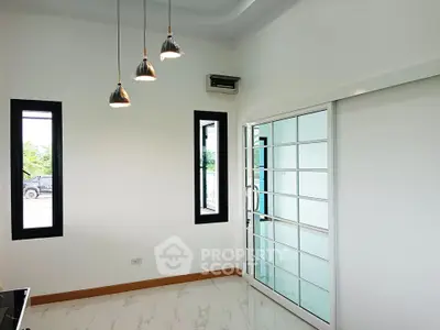 Modern interior with sliding glass doors and pendant lights in a bright room.