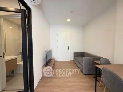 Modern living room with sleek furniture and wooden flooring in a cozy apartment.
