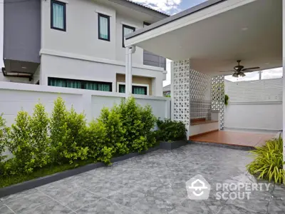 Modern house with spacious tiled patio and lush greenery