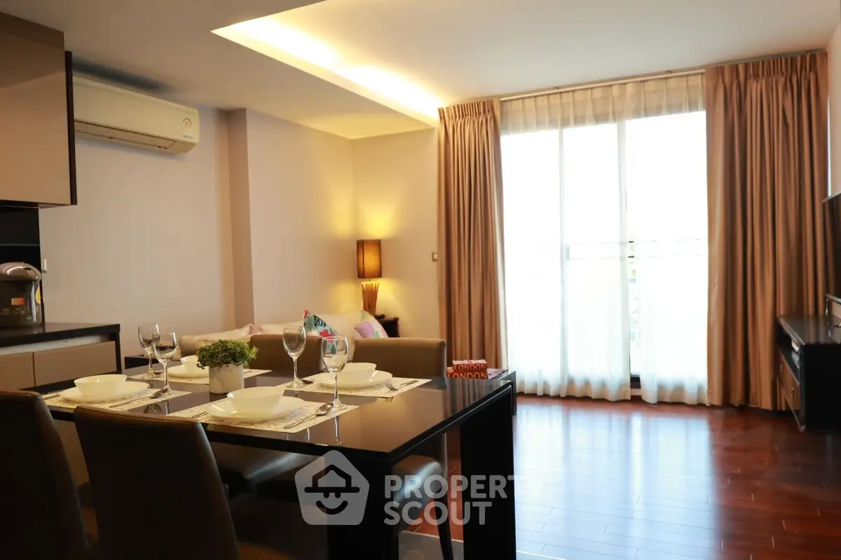 Spacious modern living room with dining area and large windows in a stylish apartment.