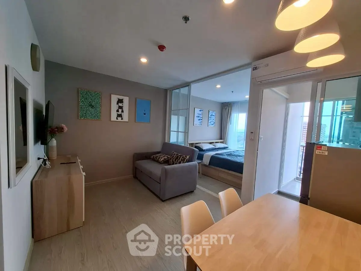 Modern open-plan living room with dining area and bedroom in stylish apartment