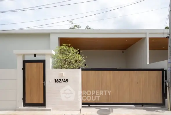 Modern minimalist house exterior with wooden gate and sleek design