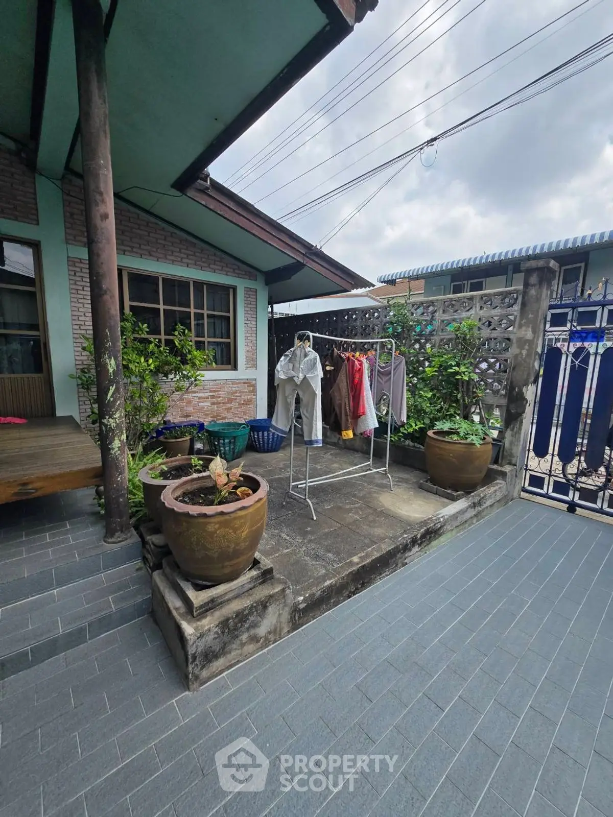 Charming outdoor patio with laundry area and potted plants in a cozy residential setting.