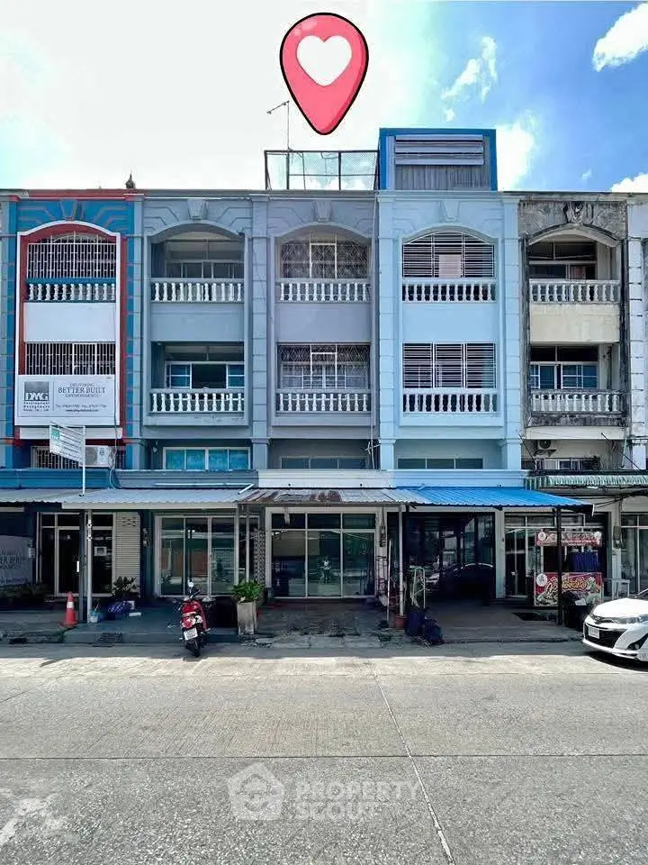 Charming multi-story commercial building with vibrant facade and ample parking space.
