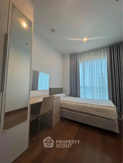 Modern bedroom with sleek design, featuring a comfortable bed, stylish mirror, and elegant curtains.