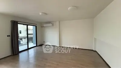 Spacious empty living room with balcony access and air conditioning