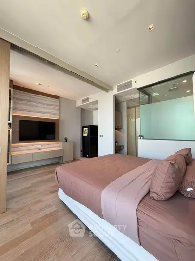 Luxurious modern bedroom with stylish decor and large TV, perfect for relaxation and comfort.