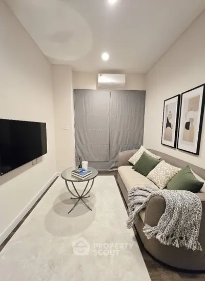 Cozy living room with modern decor, featuring a plush sofa, stylish coffee table, and wall-mounted TV.