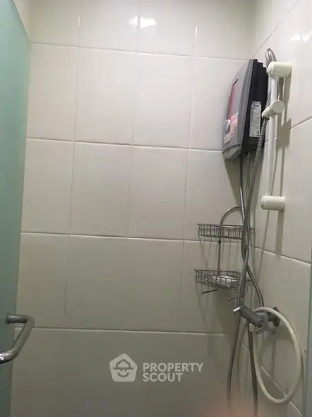 Compact bathroom with shower and water heater, ideal for efficient space use.