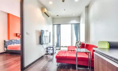 Modern living room with red sofa and wall-mounted TV in bright apartment