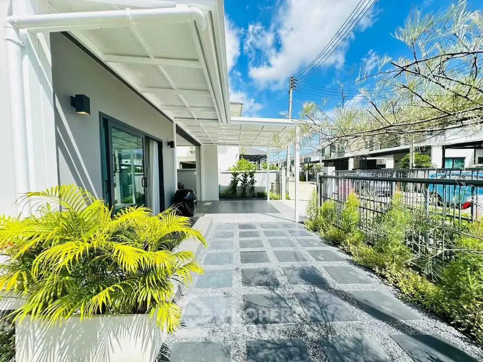Modern home exterior with spacious driveway and lush greenery under a clear blue sky.