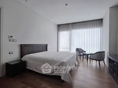 Spacious bedroom with elegant decor and large window view