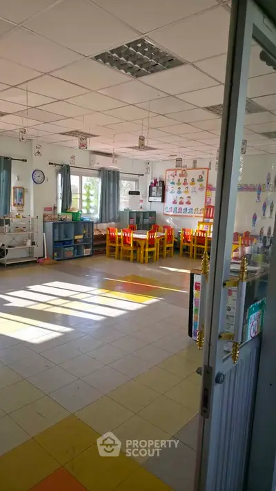 Bright and colorful classroom with yellow chairs and educational posters, ideal for a learning environment.