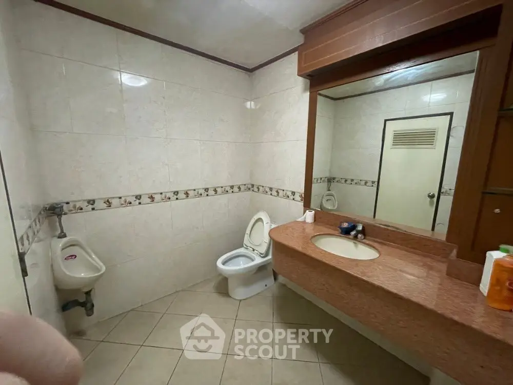 Spacious bathroom with elegant countertop and tiled walls