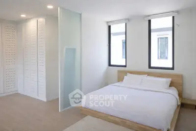Spacious modern bedroom with minimalist design and large windows