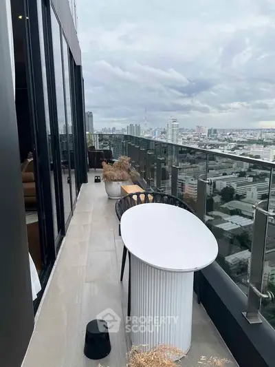Stunning high-rise balcony with panoramic city views and modern outdoor seating.