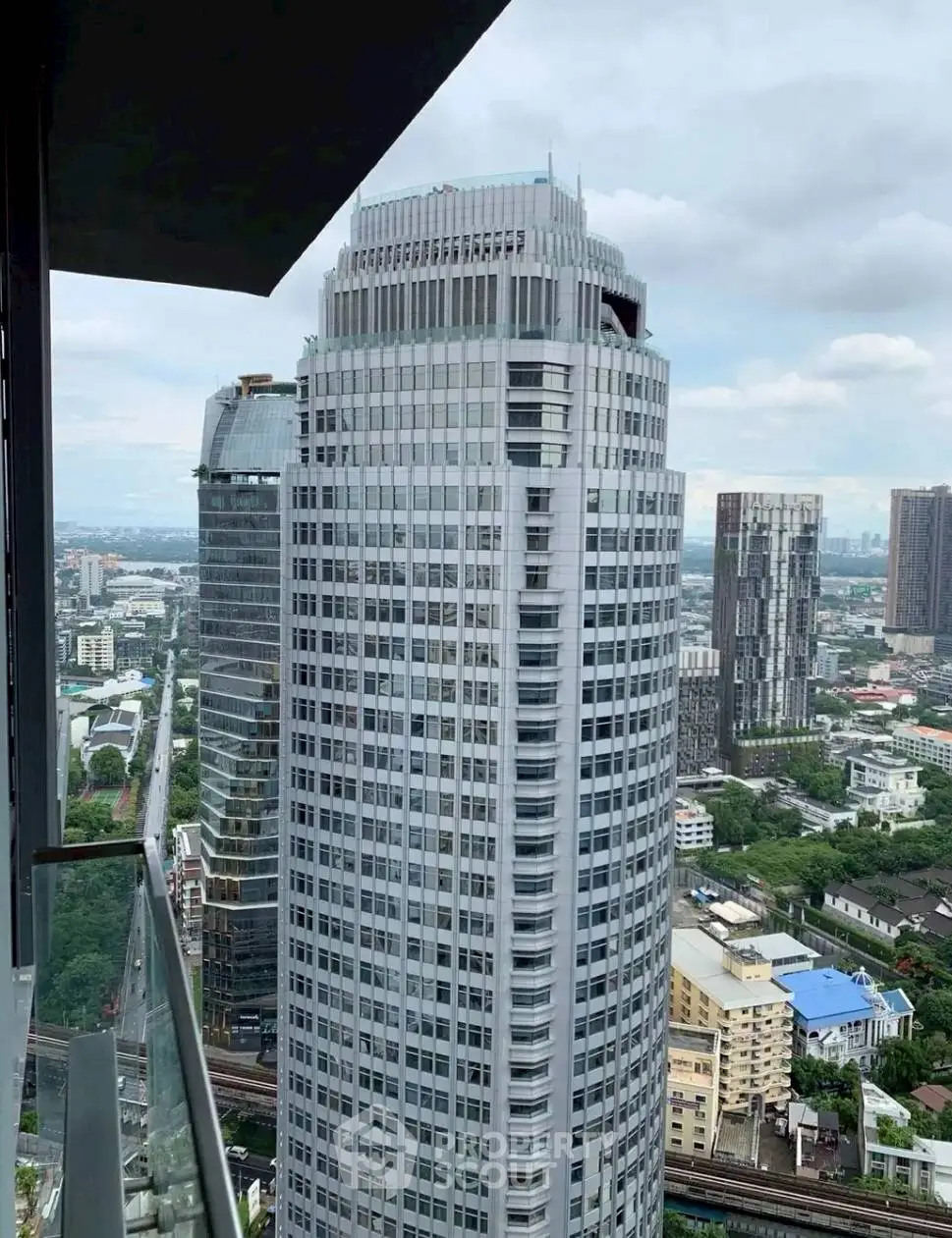 Stunning cityscape view from a high-rise balcony showcasing modern skyscrapers and urban skyline.