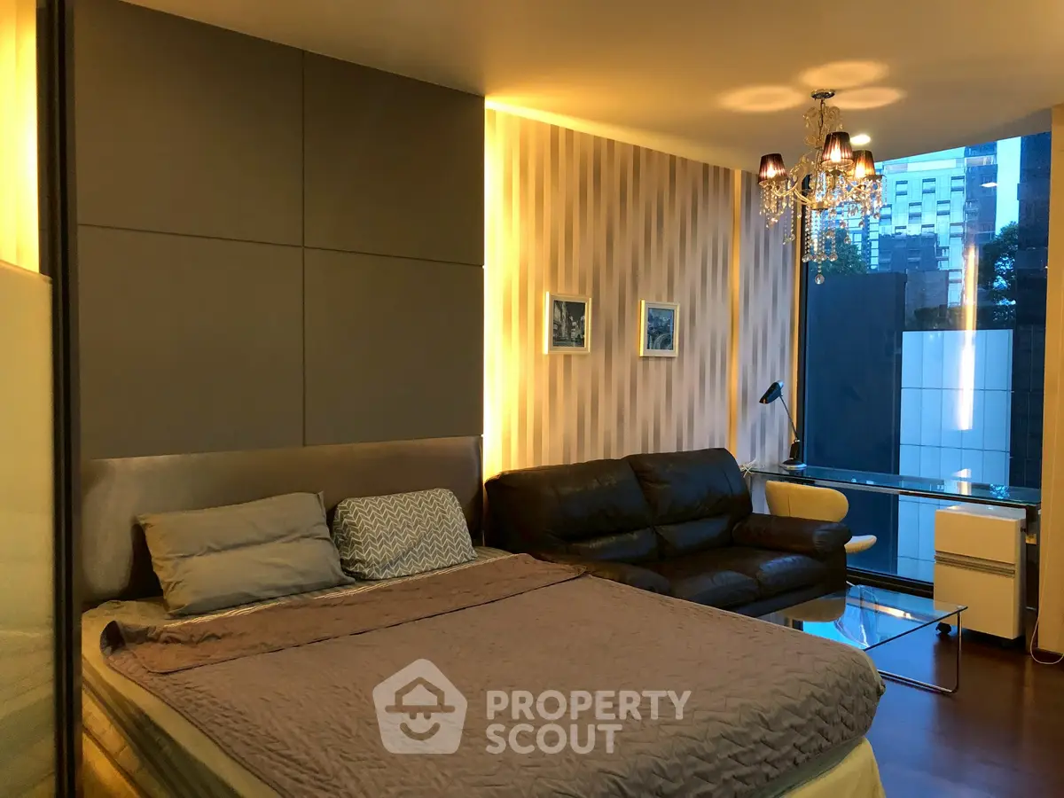 Luxurious bedroom with modern decor and city view, featuring elegant lighting and comfortable seating area.