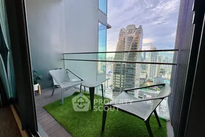 Stunning high-rise balcony with cityscape view and modern seating area.