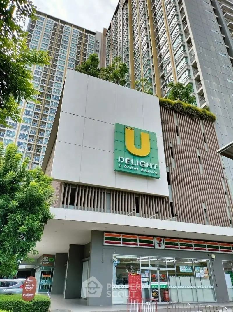 Modern high-rise building with retail space and lush greenery