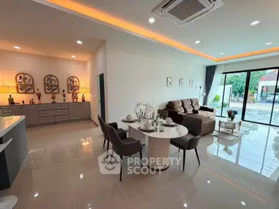Spacious modern living room with elegant dining area and large windows offering natural light.