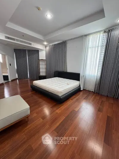 Spacious bedroom with wooden flooring and modern decor