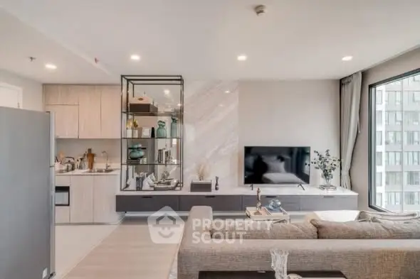 Modern living room with open kitchen and stylish decor in a high-rise apartment.