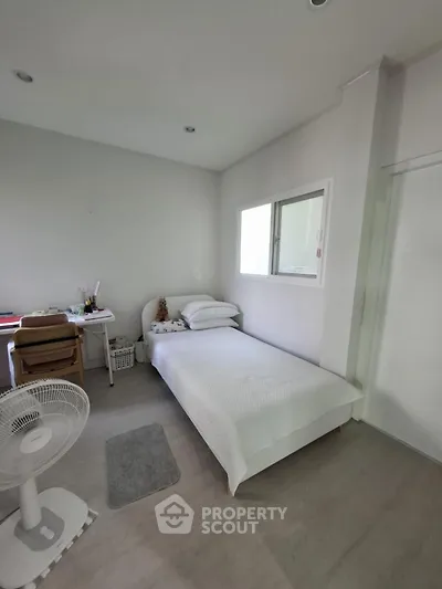Cozy minimalist bedroom with single bed and study desk, perfect for a peaceful retreat.