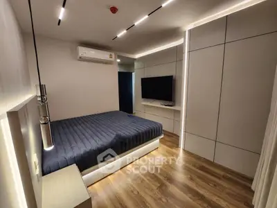 Modern bedroom with sleek design, featuring a wall-mounted TV and stylish lighting, perfect for contemporary living.