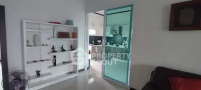 Modern open-layout living room with sleek kitchen view and stylish decor.