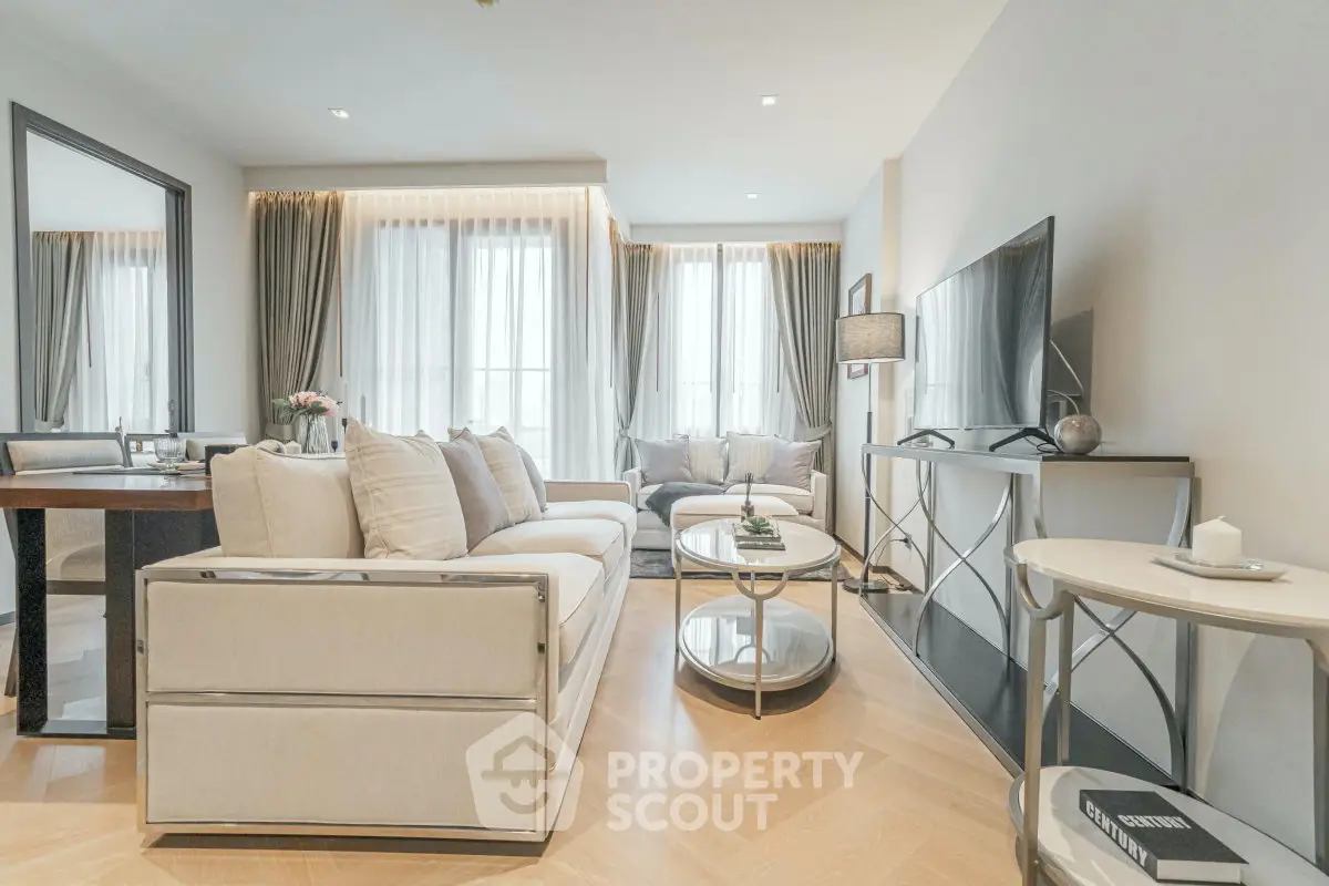 Elegant living room with modern decor and natural light, featuring a cozy sofa and stylish furniture.