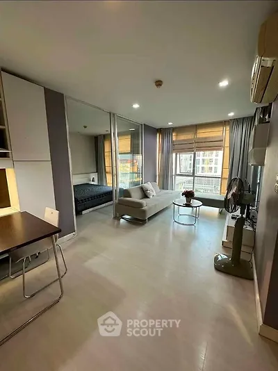 Modern studio apartment with open layout and large windows offering city views.