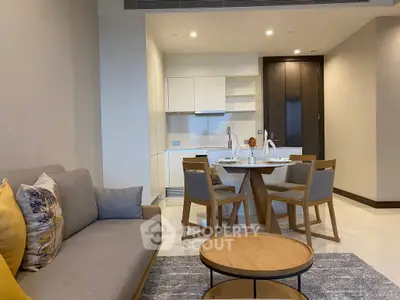 Modern open-plan living room and kitchen with stylish furniture and neutral tones.