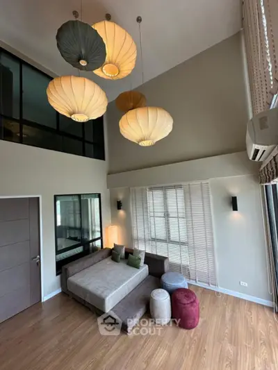 Spacious modern living room with high ceiling and stylish pendant lights