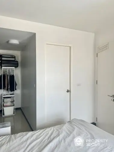 Bright and airy bedroom with a spacious built-in wardrobe, showcasing a minimalist design with a clean white palette, perfect for restful living.