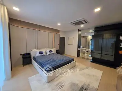 Spacious modern bedroom with stylish decor and ample natural light