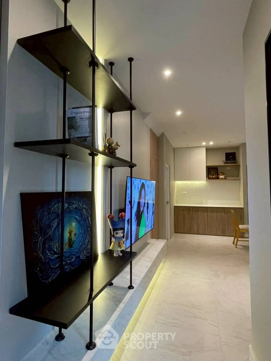 Modern living room with sleek shelving and ambient lighting, showcasing contemporary design and open layout.