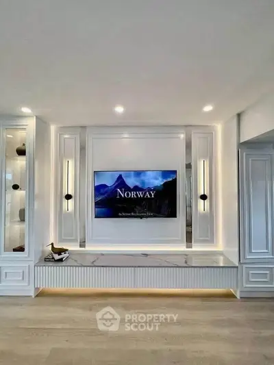 Elegant living room with built-in TV and modern lighting, showcasing a sleek and stylish design.
