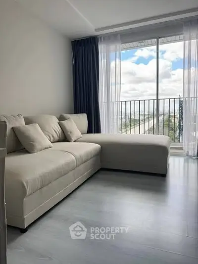 Modern living room with large sofa and balcony view