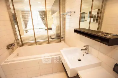 Modern bathroom with bathtub and sleek fixtures in contemporary apartment.