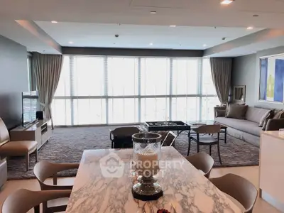 Luxurious modern living room with elegant decor and large windows offering abundant natural light.