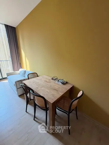 Modern living room with wooden dining table and cozy sofa near large window