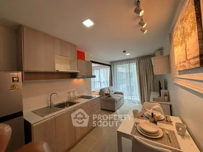 Modern open-layout kitchen and living room with stylish decor and natural light.