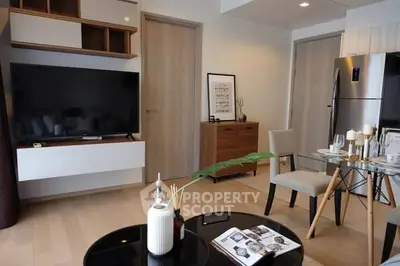 Modern living room with sleek furniture and large TV, perfect for relaxation.