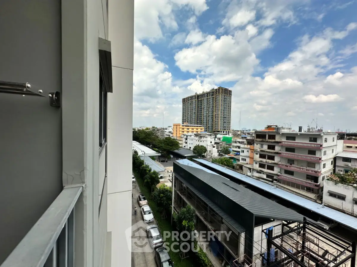Stunning cityscape view from a high-rise balcony with clear blue skies.